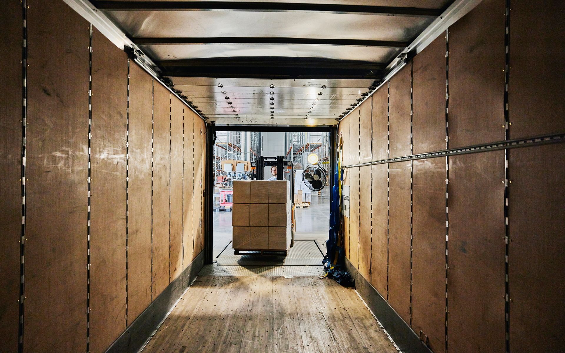 A forklift is loading boxes into a truck in a warehouse.