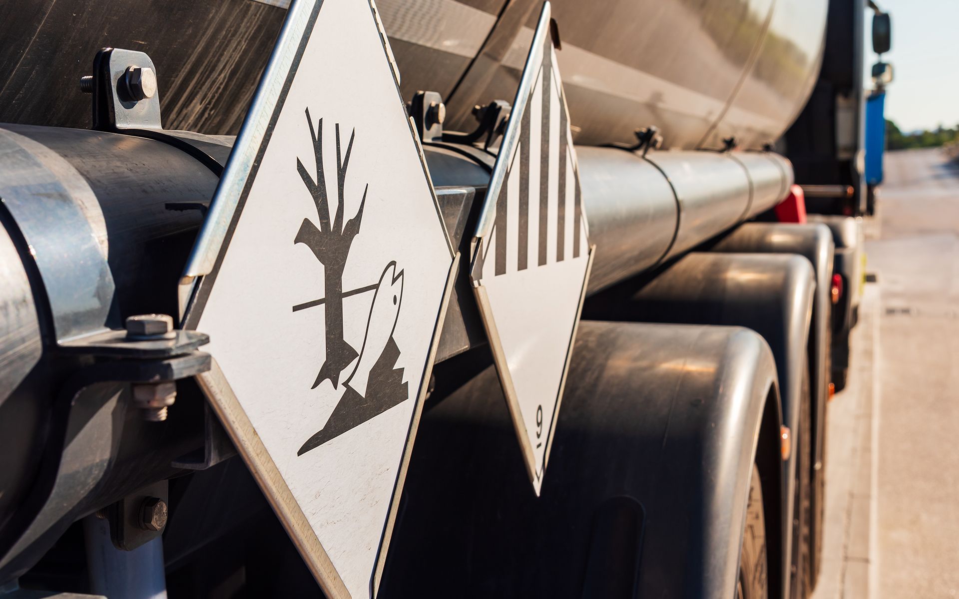 A truck with a sign on the back that says ' hazardous '