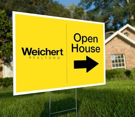 A yellow open house sign with an arrow pointing to the right in front of a brick house.