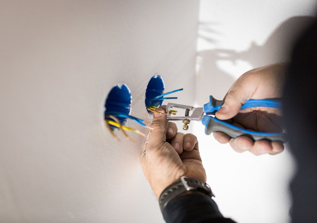 A person is cutting a wire with a pair of pliers.