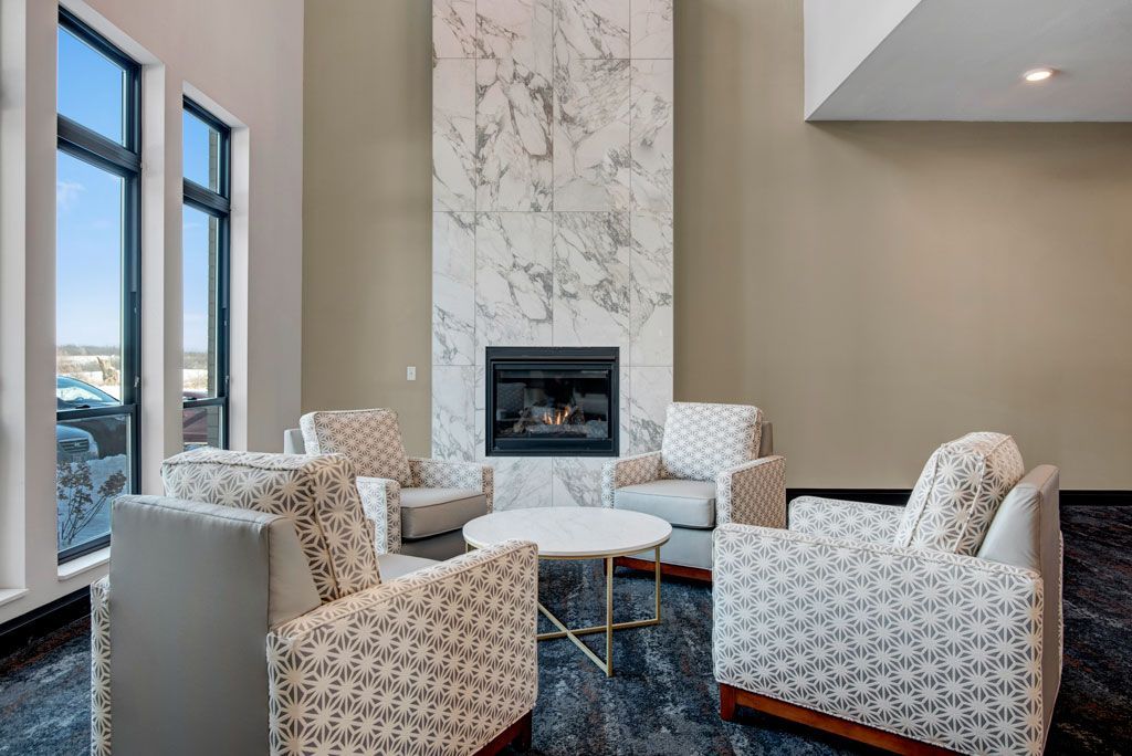 Modern living room with four patterned chairs around a coffee table and a fireplace.