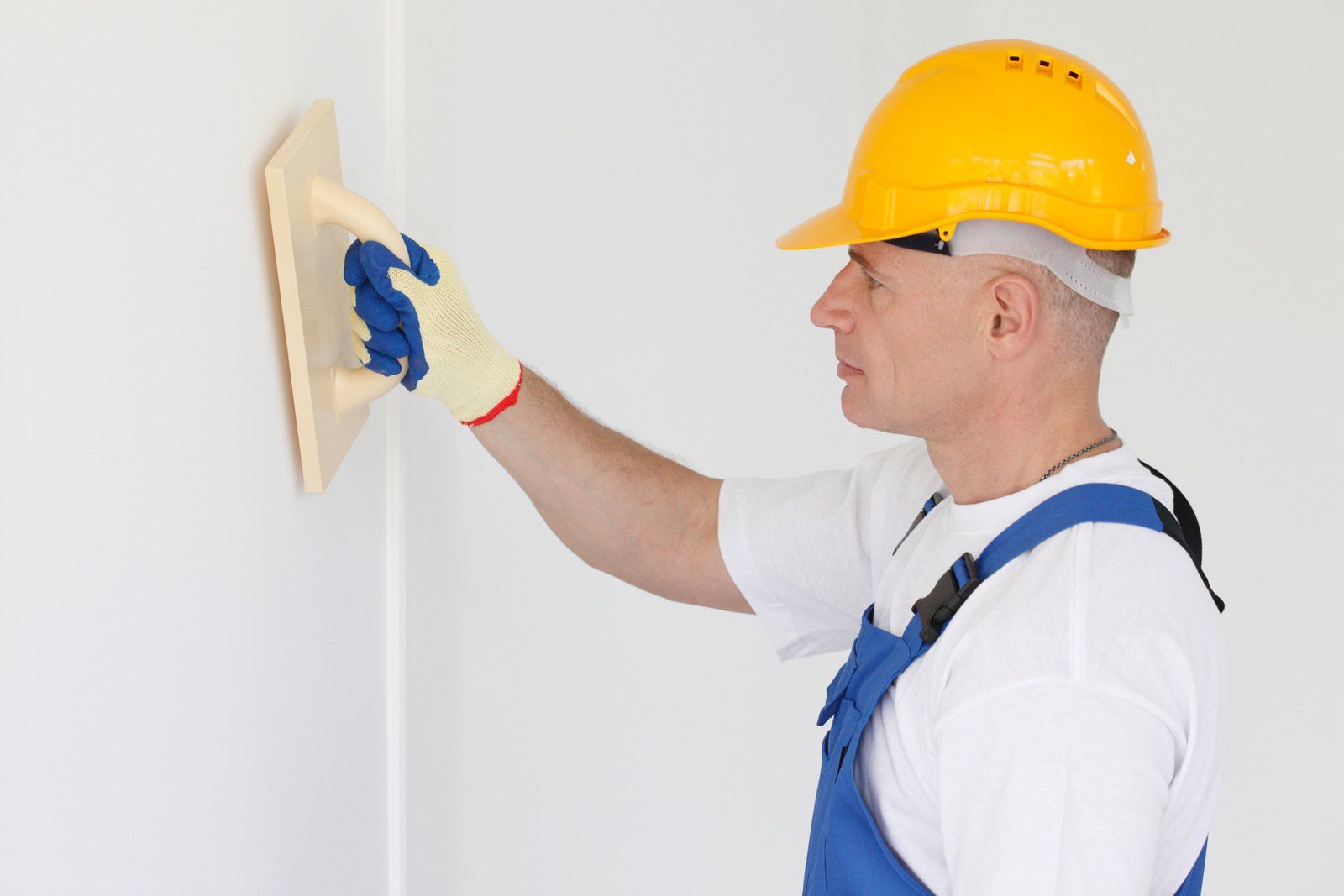 sanding wallboard after a skim coat on a finished wall