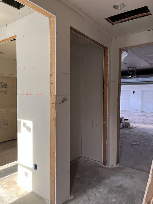 closet and hallway with new dry wall leading to garage at North Tampa project