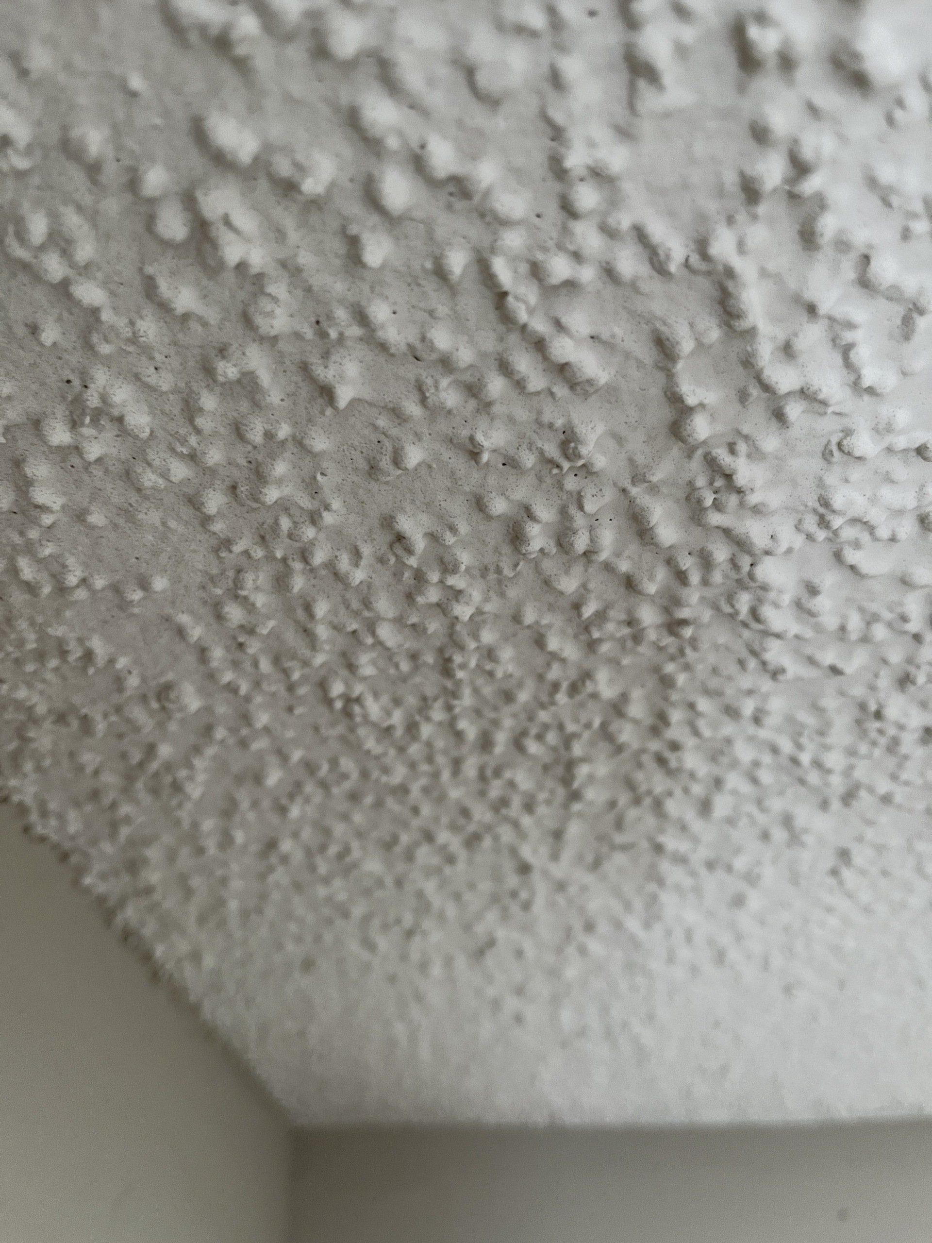 extreme close up of popcorn texture on ceiling in older apartment