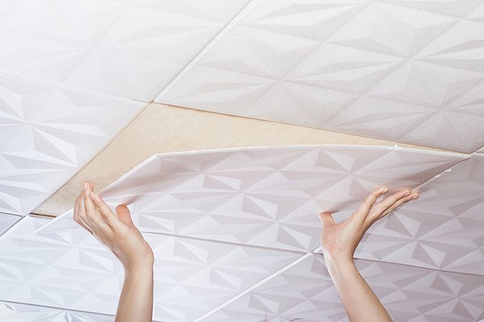 Distinctive modern ceiling tile design being glued into place