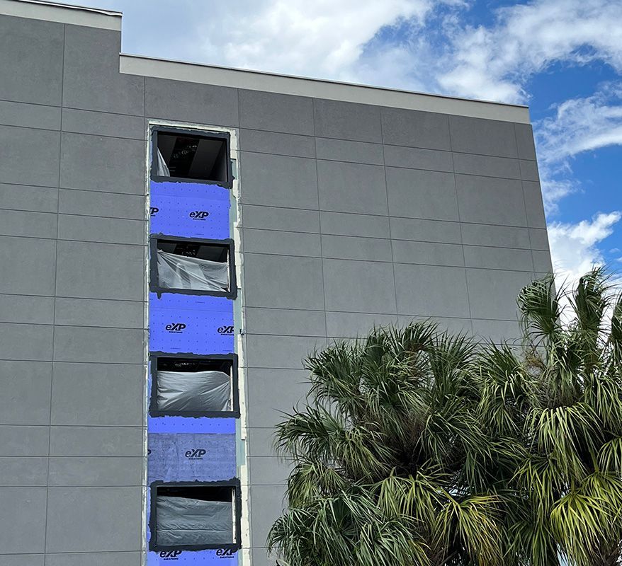 five story hotel near Tampa airport, exterior painted stucco in dark gray