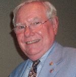 A man in a suit and tie is smiling for the camera.