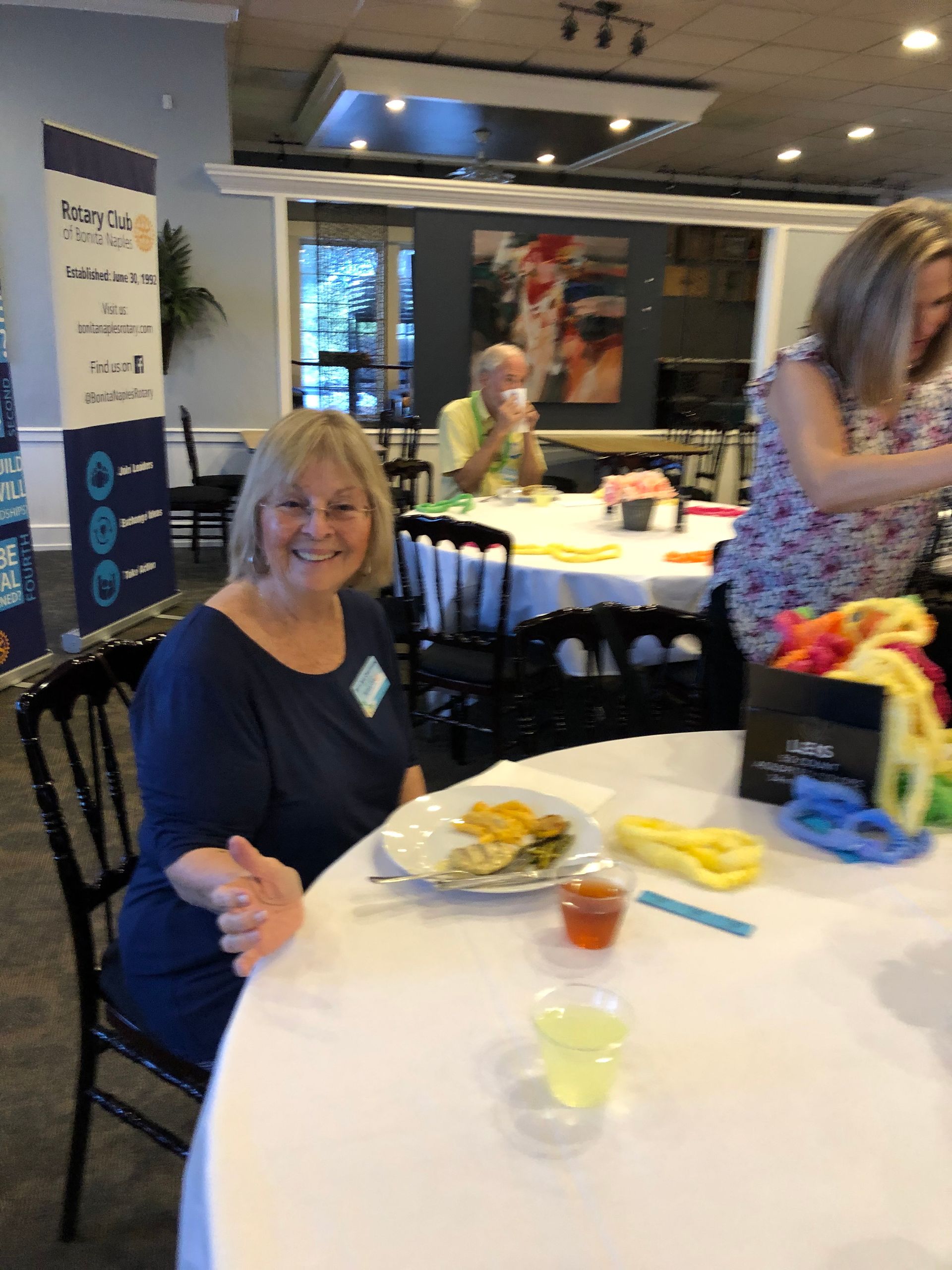 A woman is sitting at a table with a plate of food on it