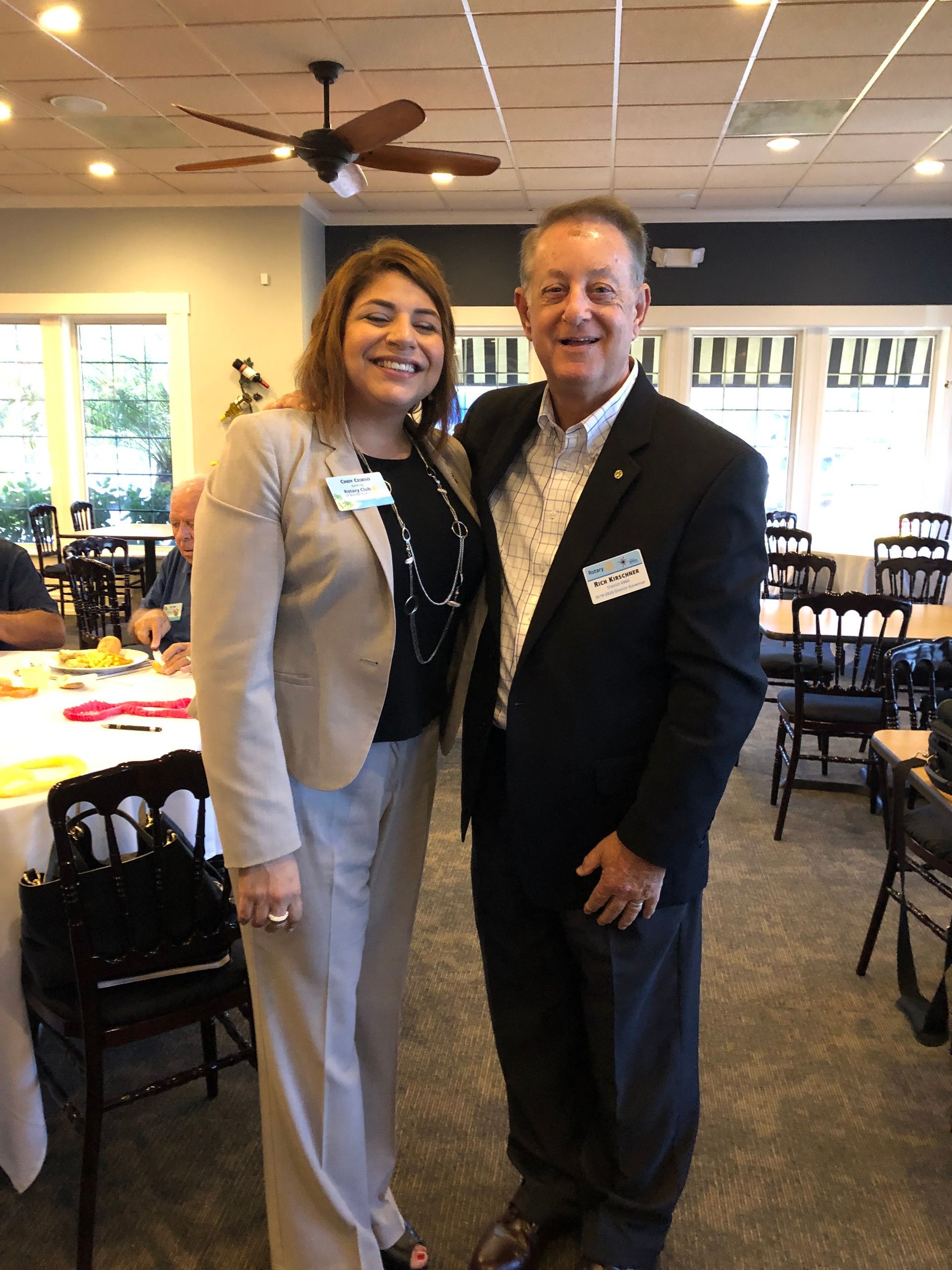 A man and a woman are posing for a picture in a restaurant.