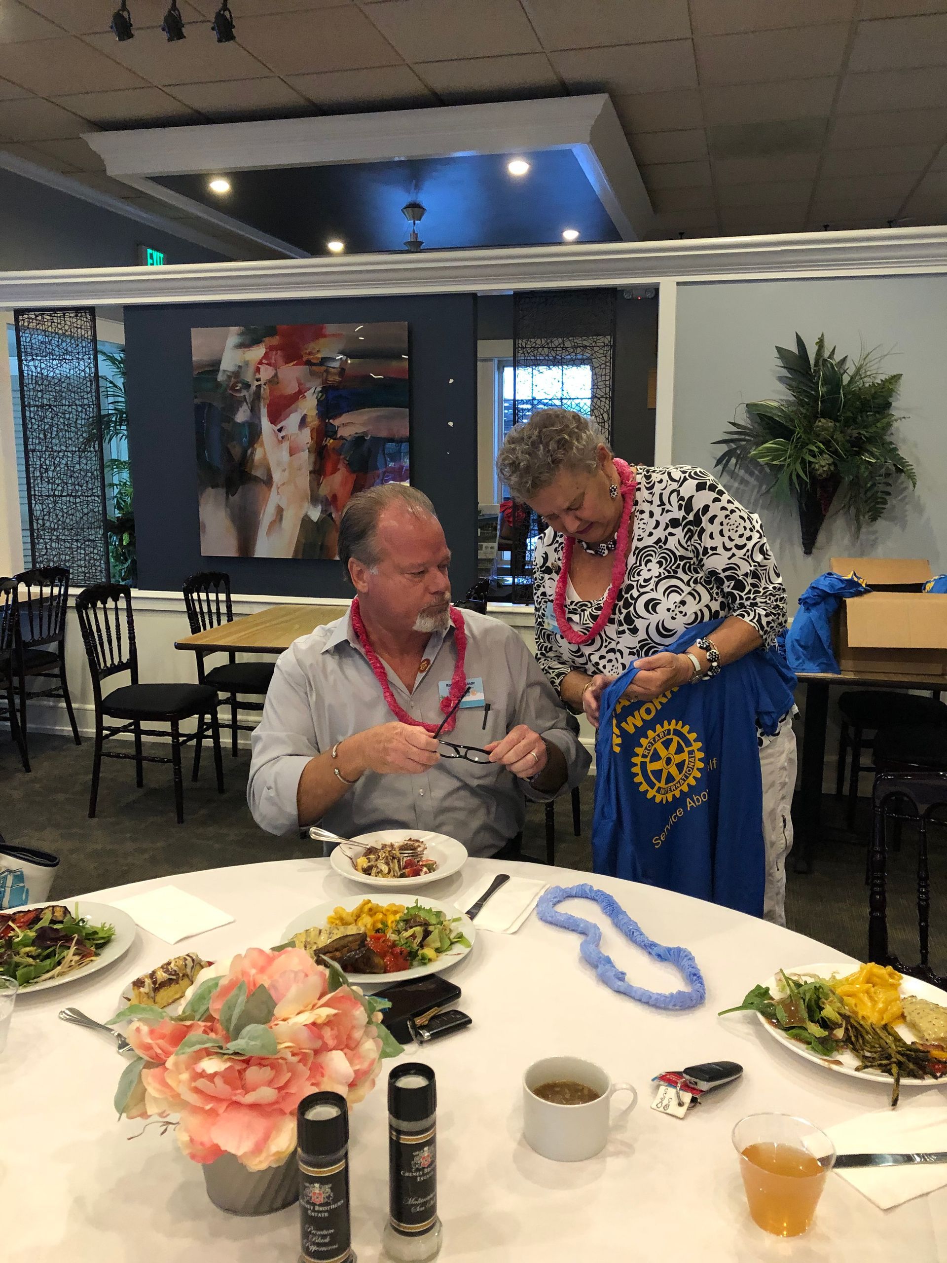 A man and a woman are sitting at a table with plates of food.