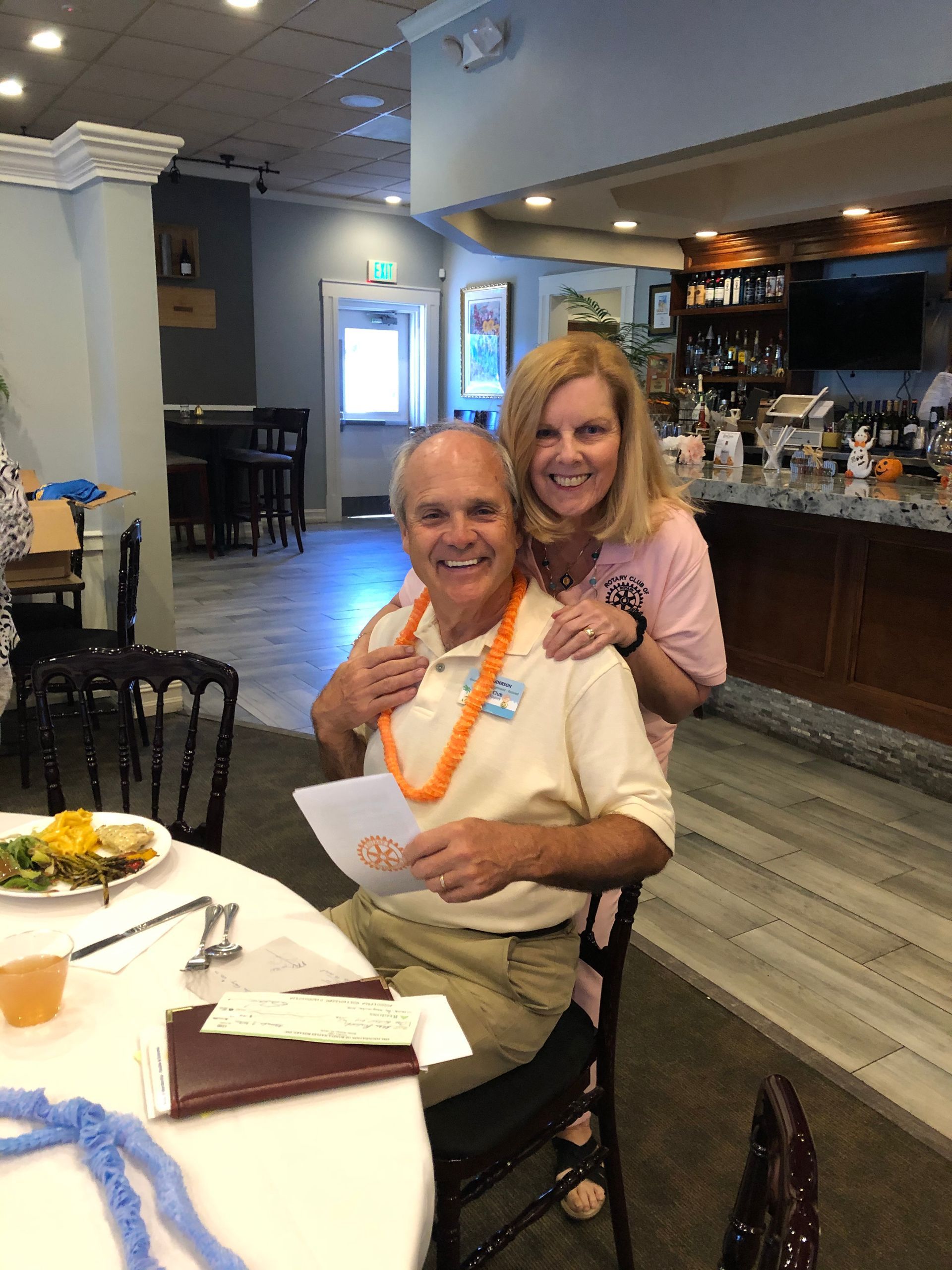 A man and woman are posing for a picture while sitting at a table.