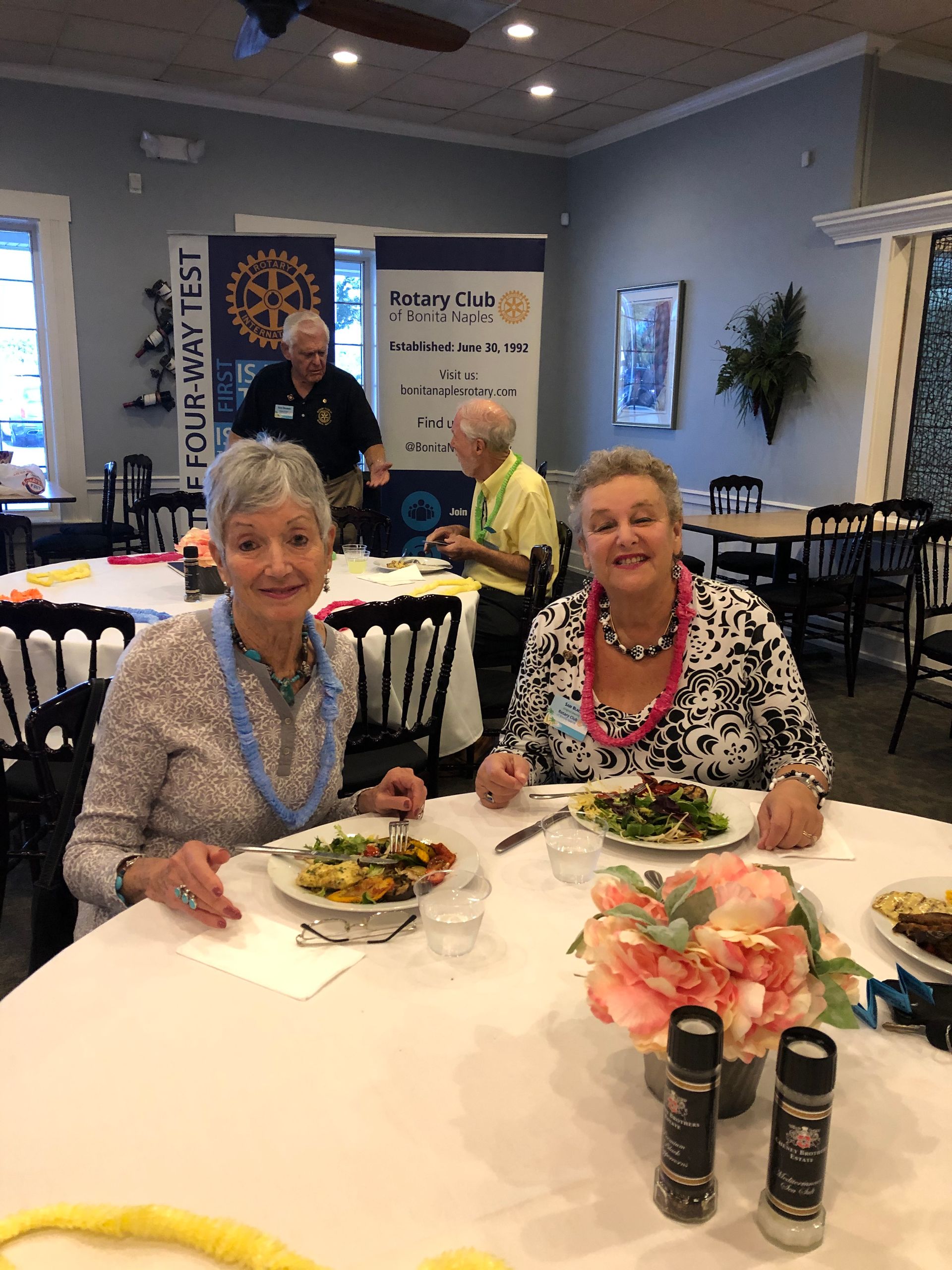 Two women are sitting at a table in a restaurant eating food.
