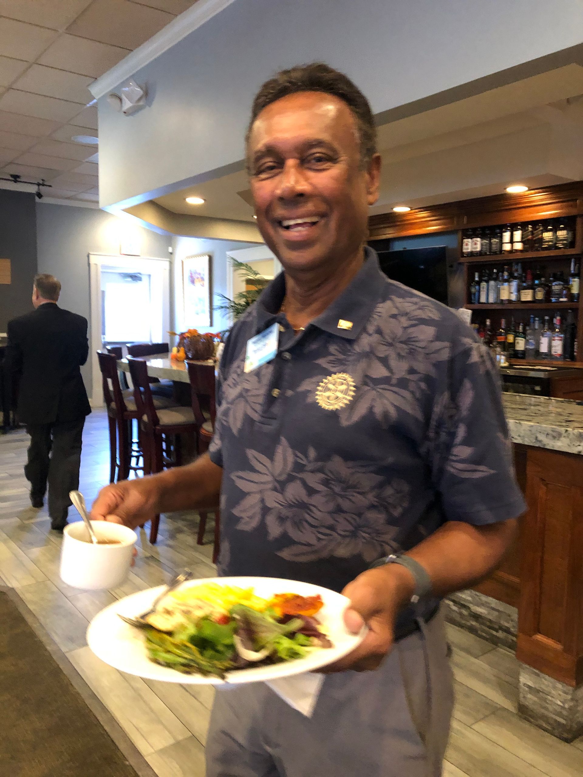A man is holding a plate of food in a restaurant.