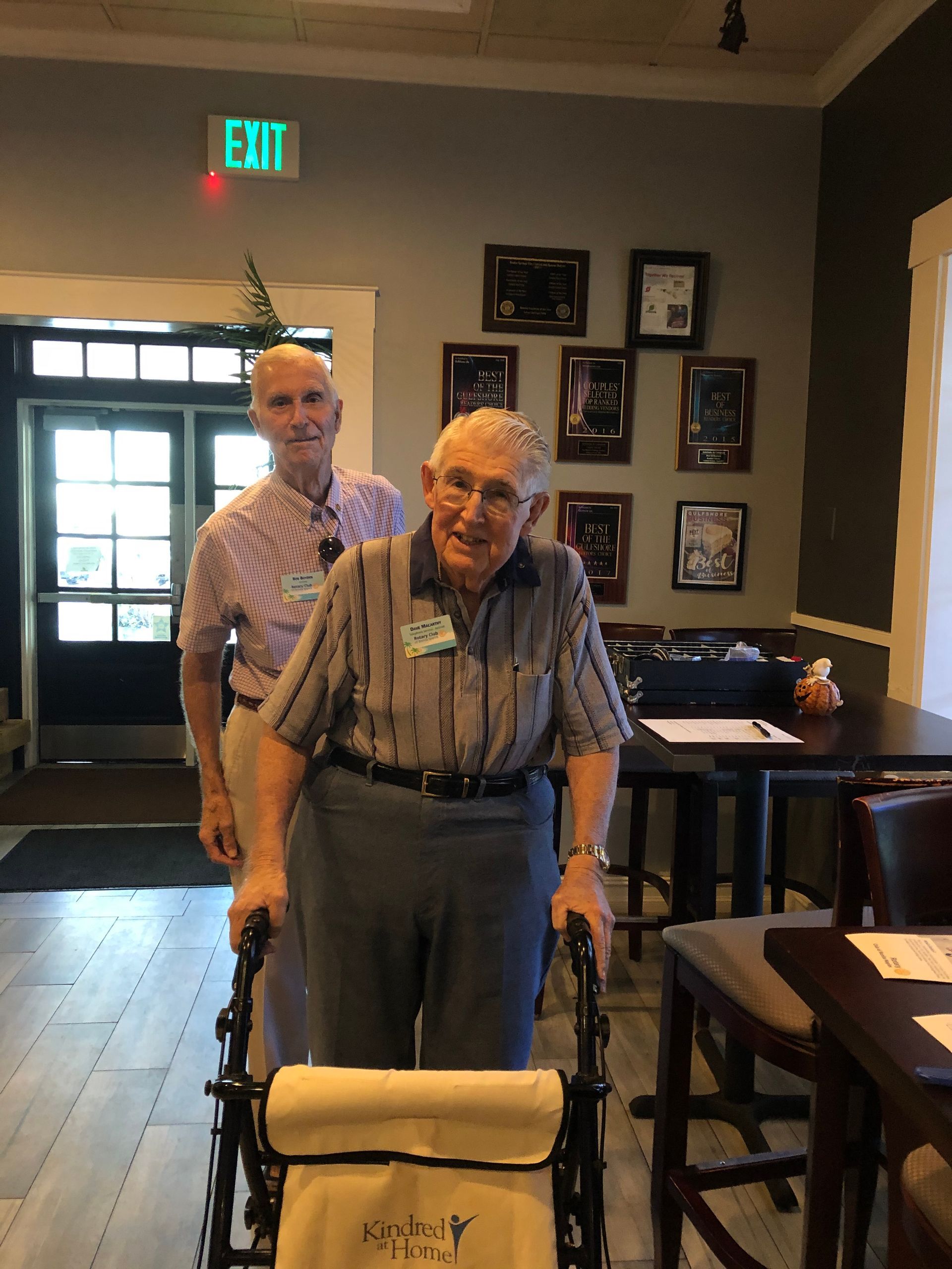 A man in a wheelchair is being pushed by another man