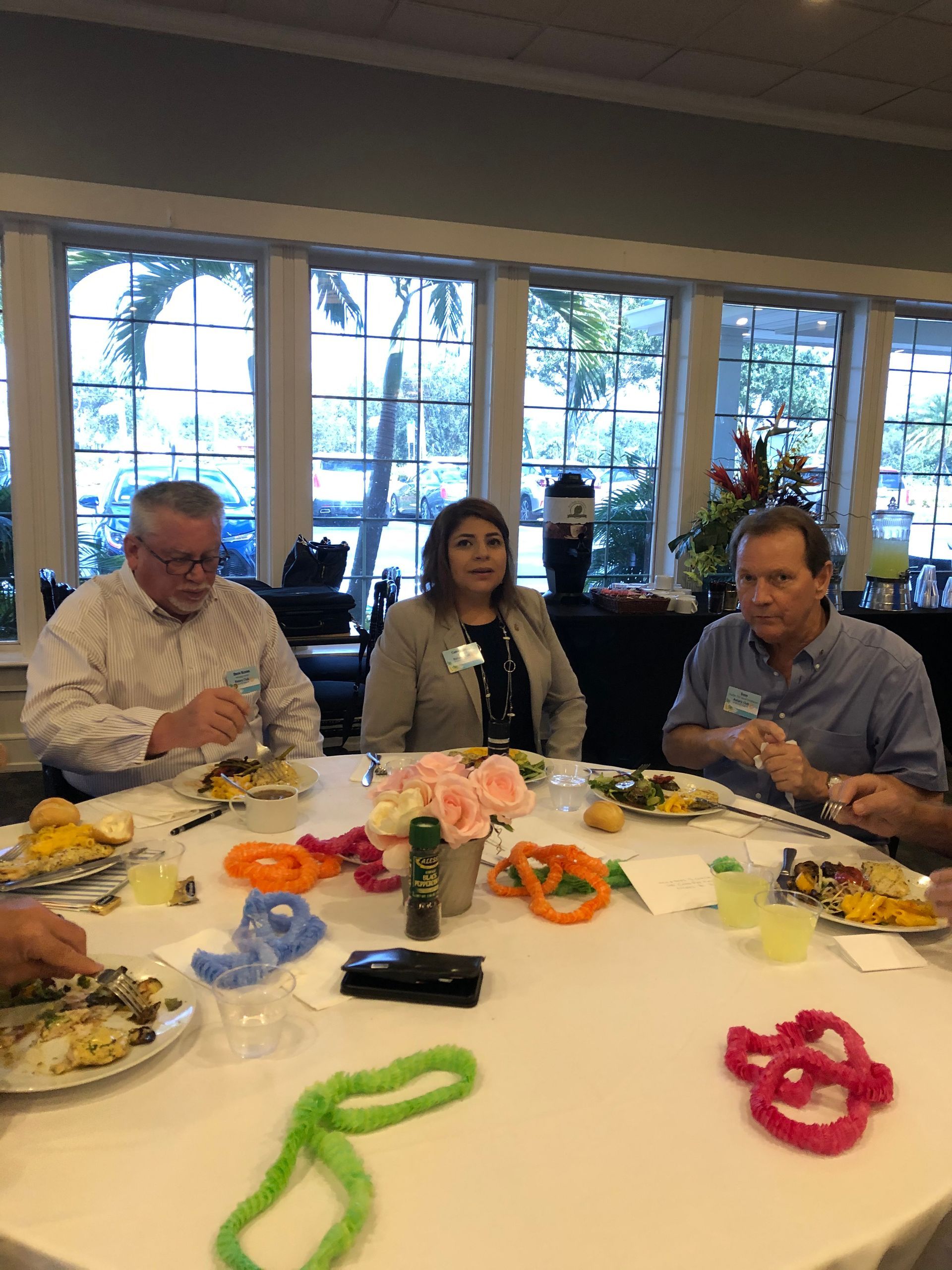 A group of people are sitting around a table with plates of food.