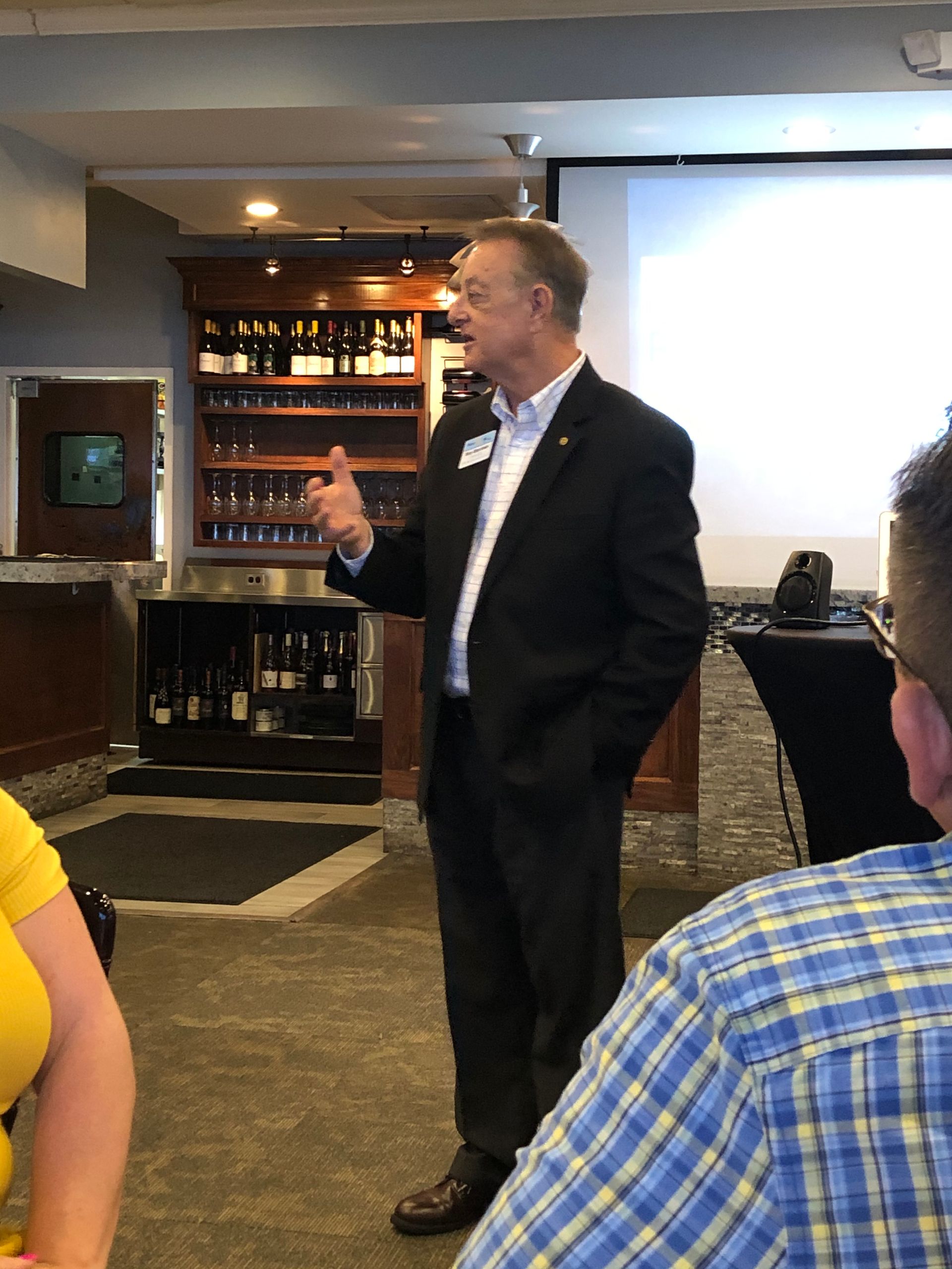 A man in a suit is talking to a group of people