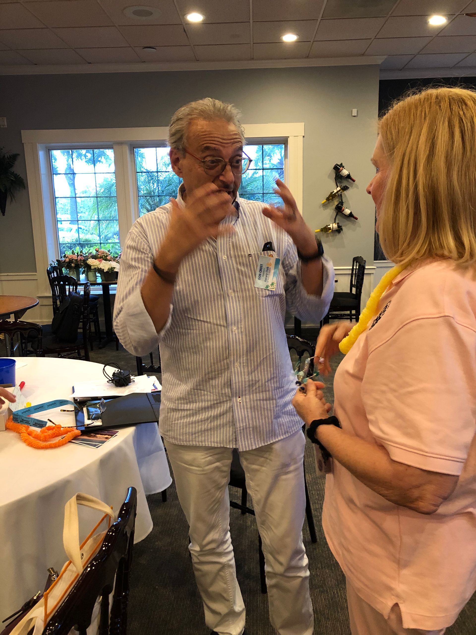 A man and a woman are standing in a room talking to each other.