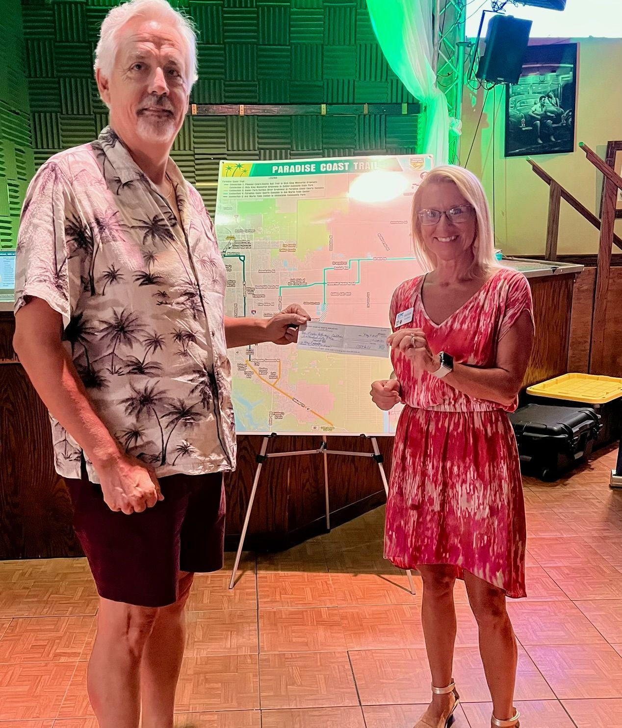 A man and a woman are standing next to each other in front of a map.