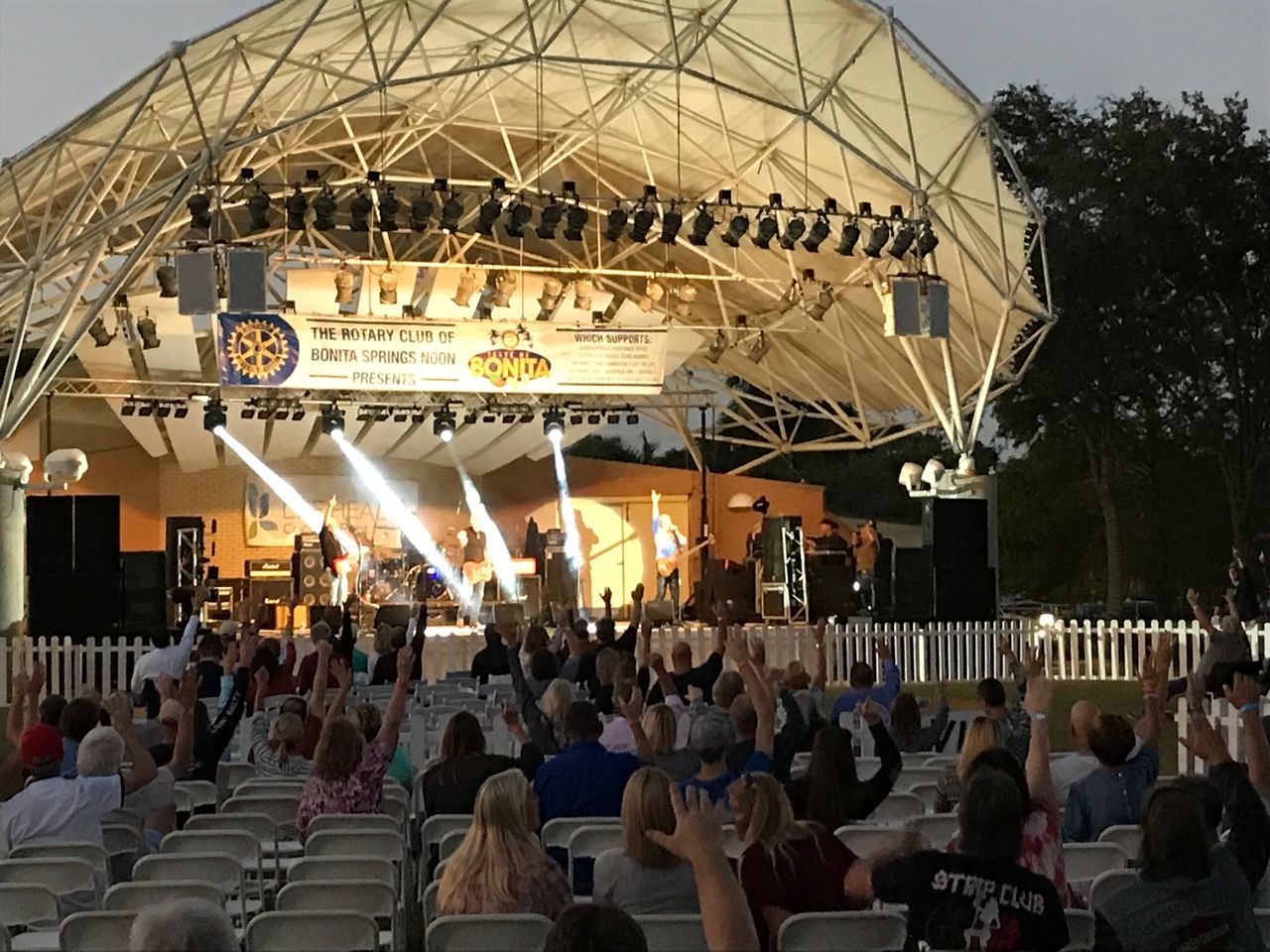 A crowd of people are watching a band on a stage