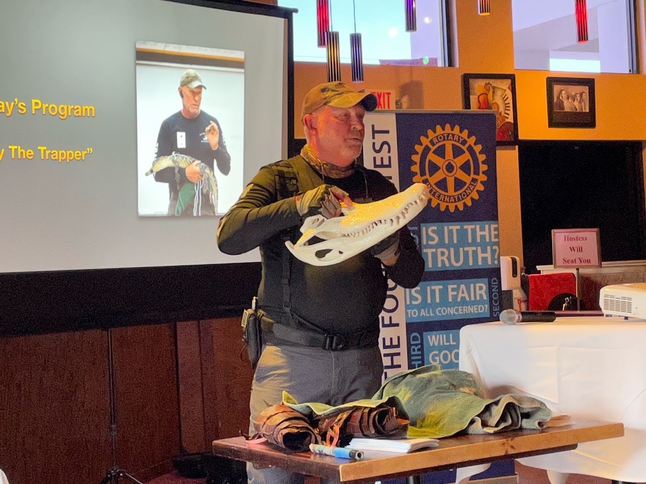 A man is giving a presentation in front of a rotary sign