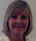 A close up of a woman 's face smiling and wearing a white shirt.