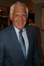 A man in a suit and tie is smiling for the camera.