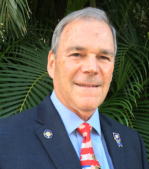 A man in a suit and tie is smiling for the camera.