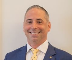 A man in a suit and tie is smiling for the camera.