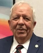 A man in a suit and tie is smiling for the camera.