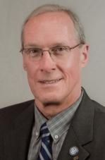 A man in a suit and tie is smiling for the camera.