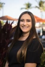 The woman is wearing a black shirt and smiling for the camera.