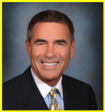 A man in a suit and tie is smiling for the camera