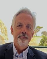 A man with a beard is wearing a suit and tie.