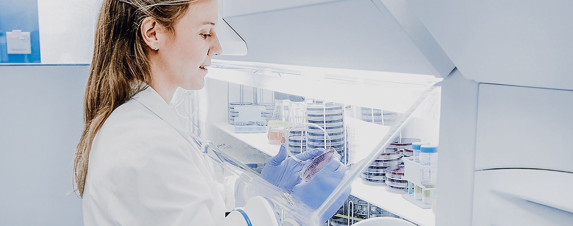 A woman in a lab coat is working in a laboratory.