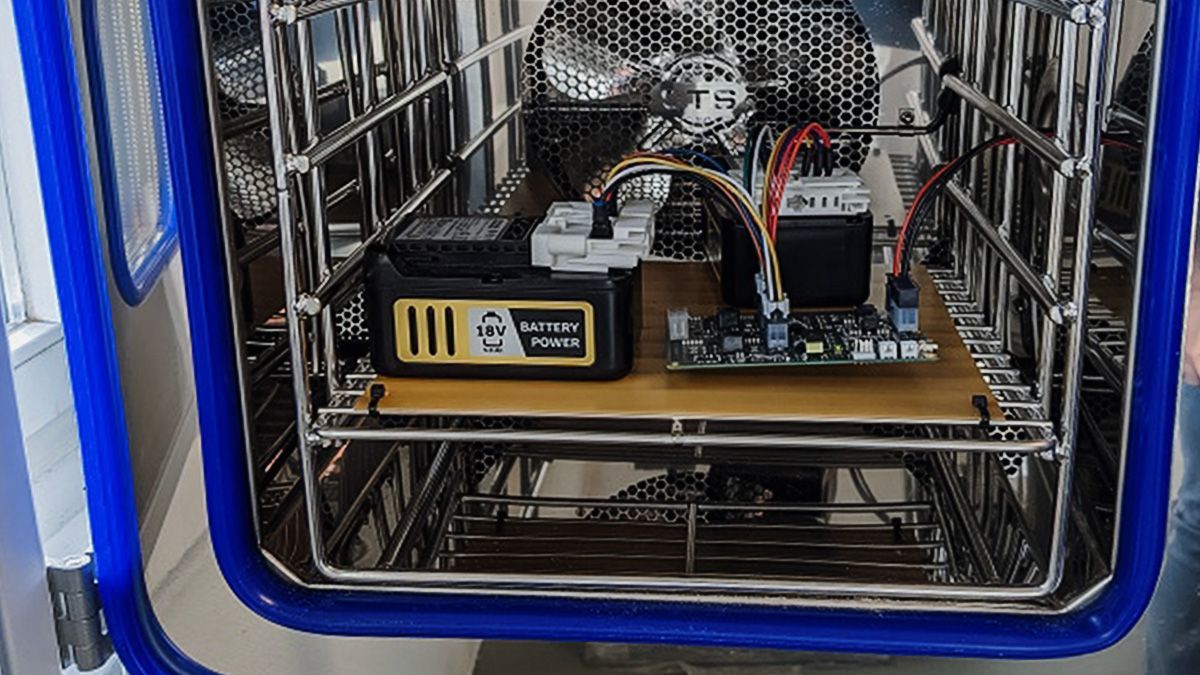 A shopping cart filled with electronics and a battery.