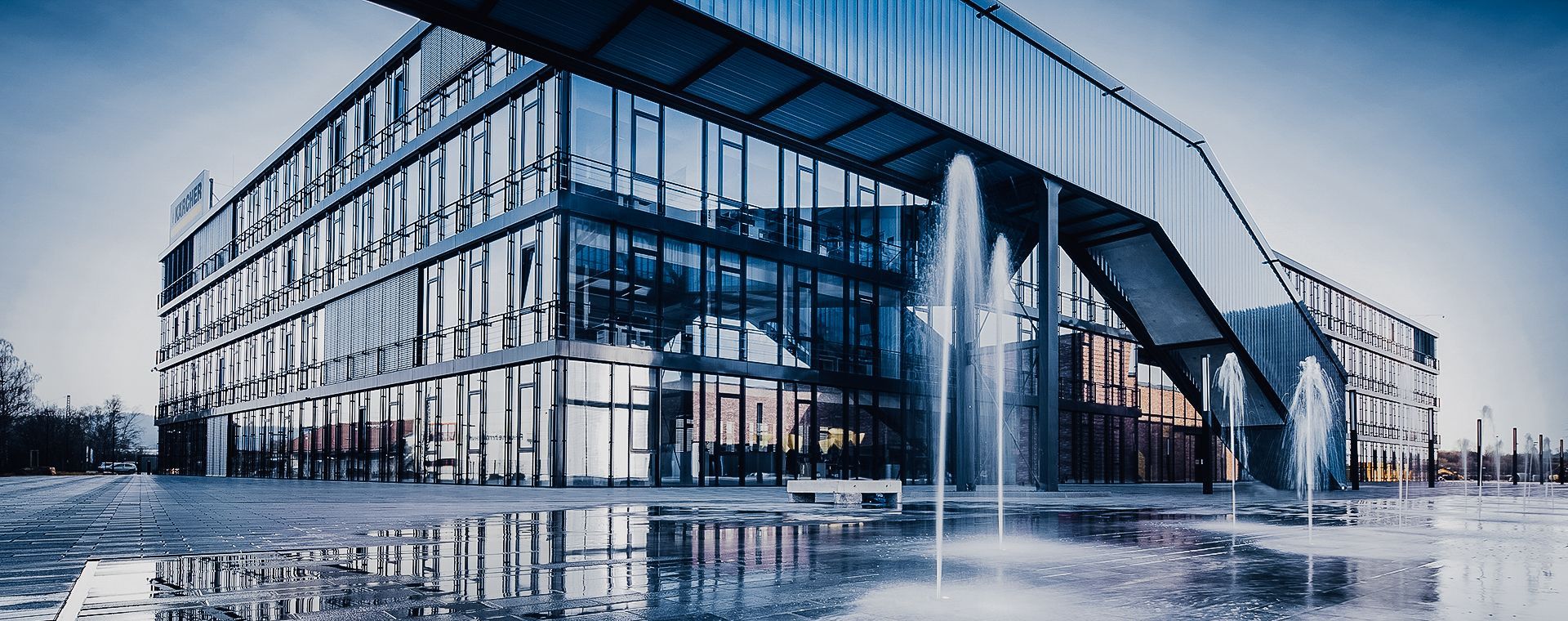 A large building with a lot of windows and a fountain in front of it.