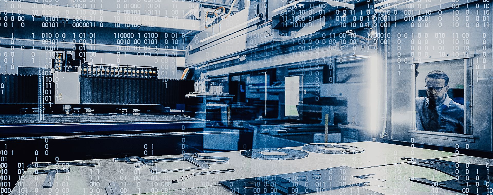 A man is standing in front of a machine in a factory.