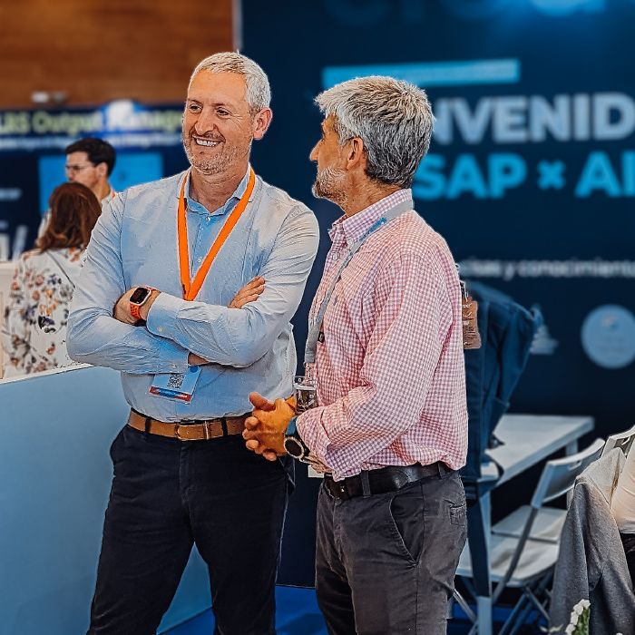 Two men are standing next to each other in front of a sign that says SAP.