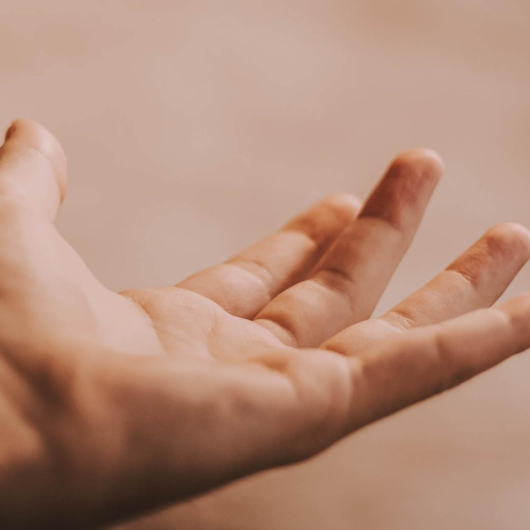Open de hand, met de handpalm naar boven, en de vingers licht gebogen, tegen een neutrale achtergrond.