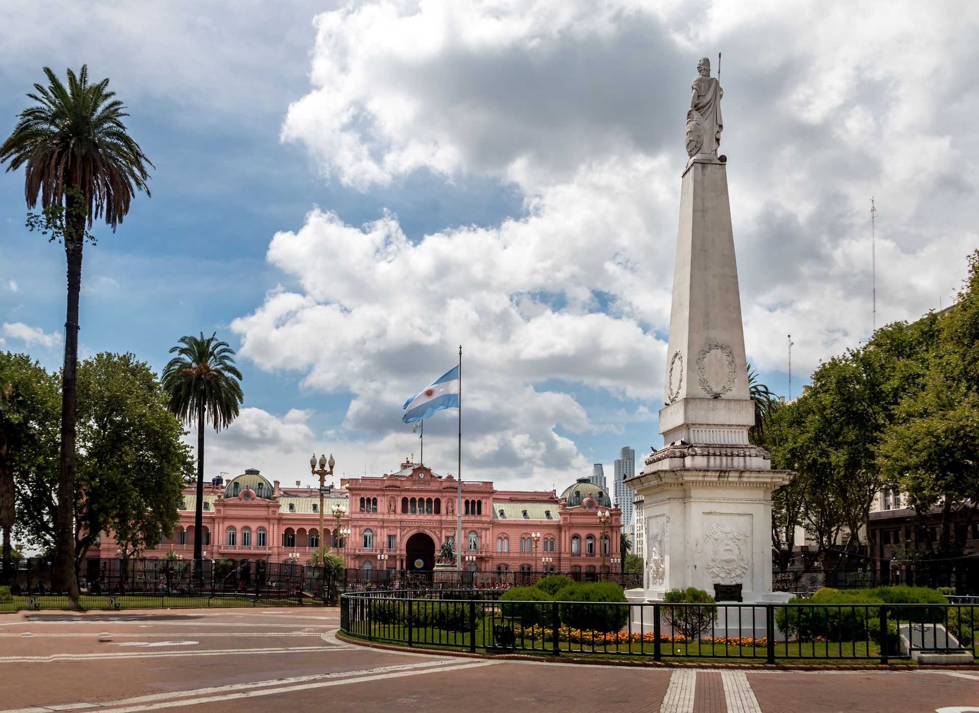 Una estatua frente a un gran edificio rosado.