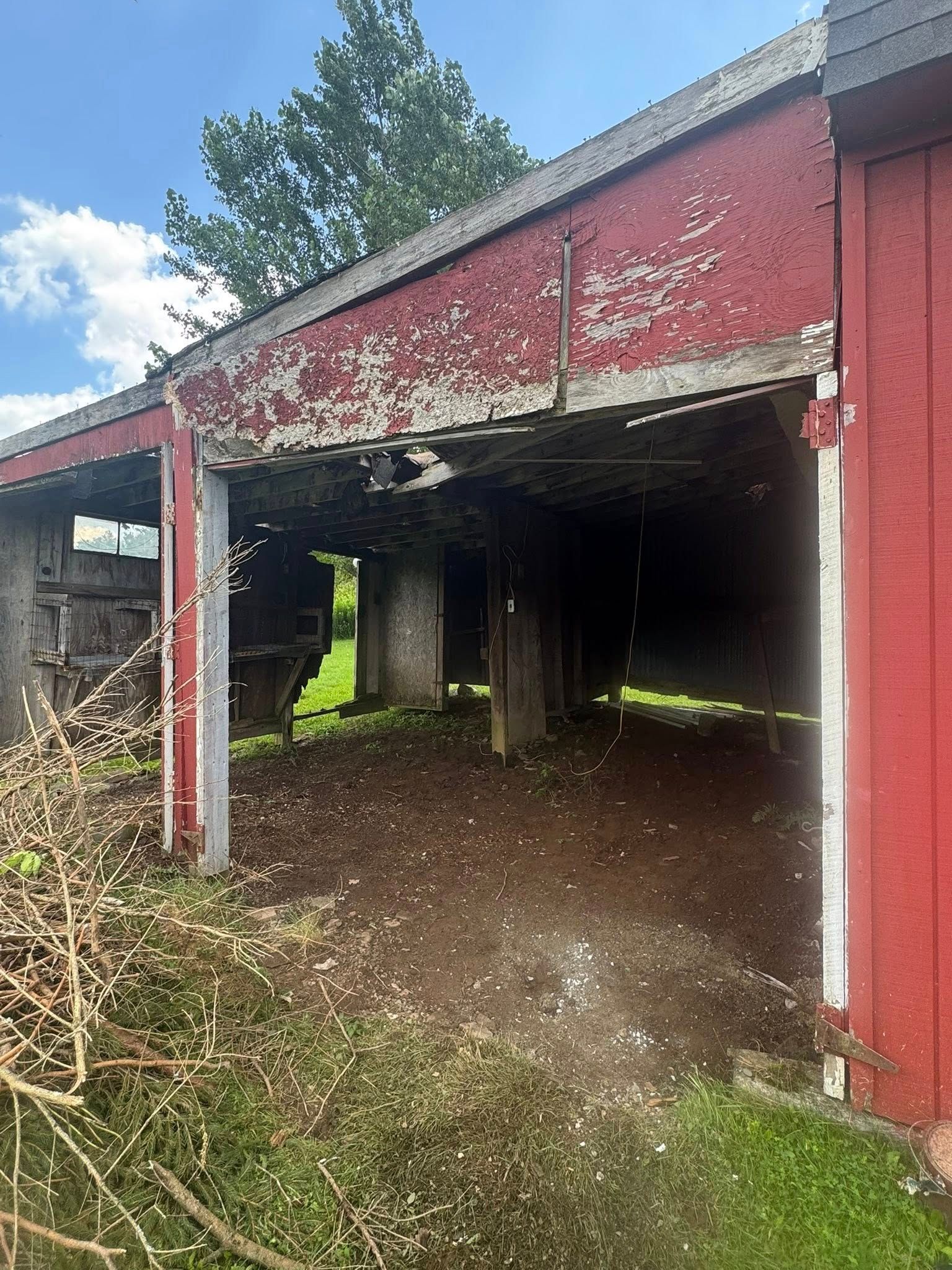 A red barn is sitting in the middle of a grassy field.