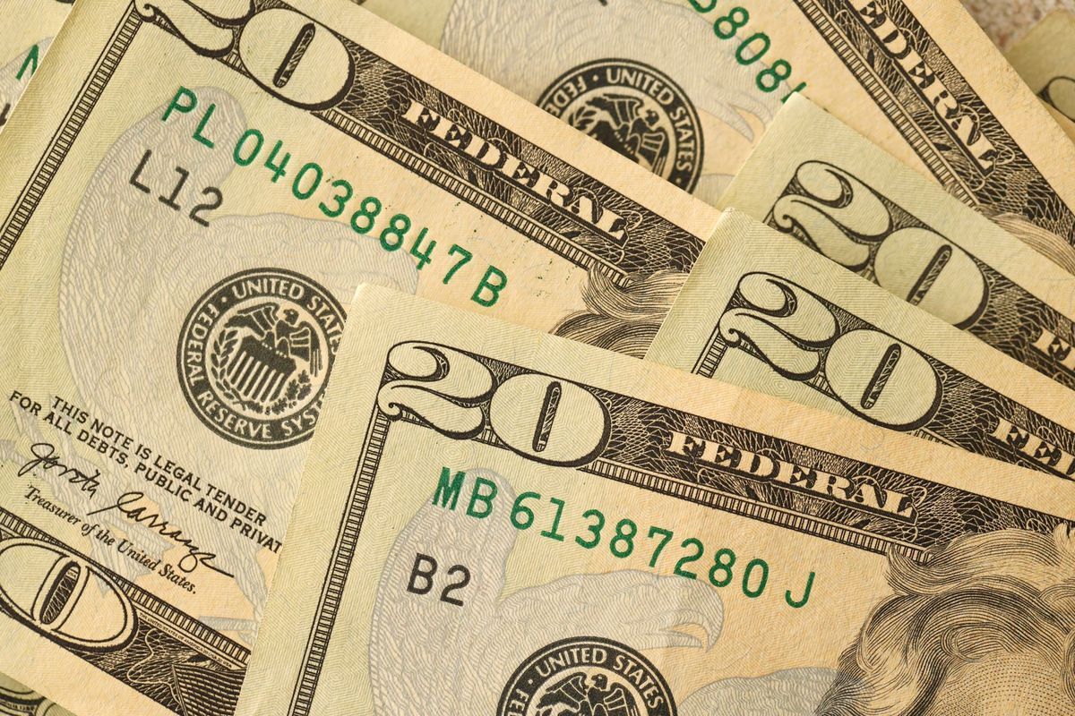 Close-up of several twenty-dollar bills fanned out, showing details of the currency.