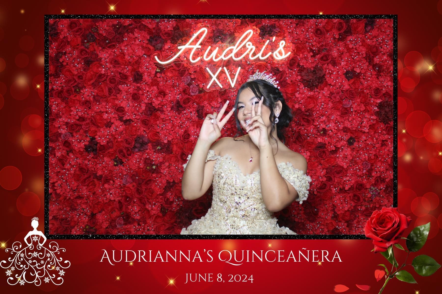 A woman in a gold dress is standing in front of a wall of red roses.