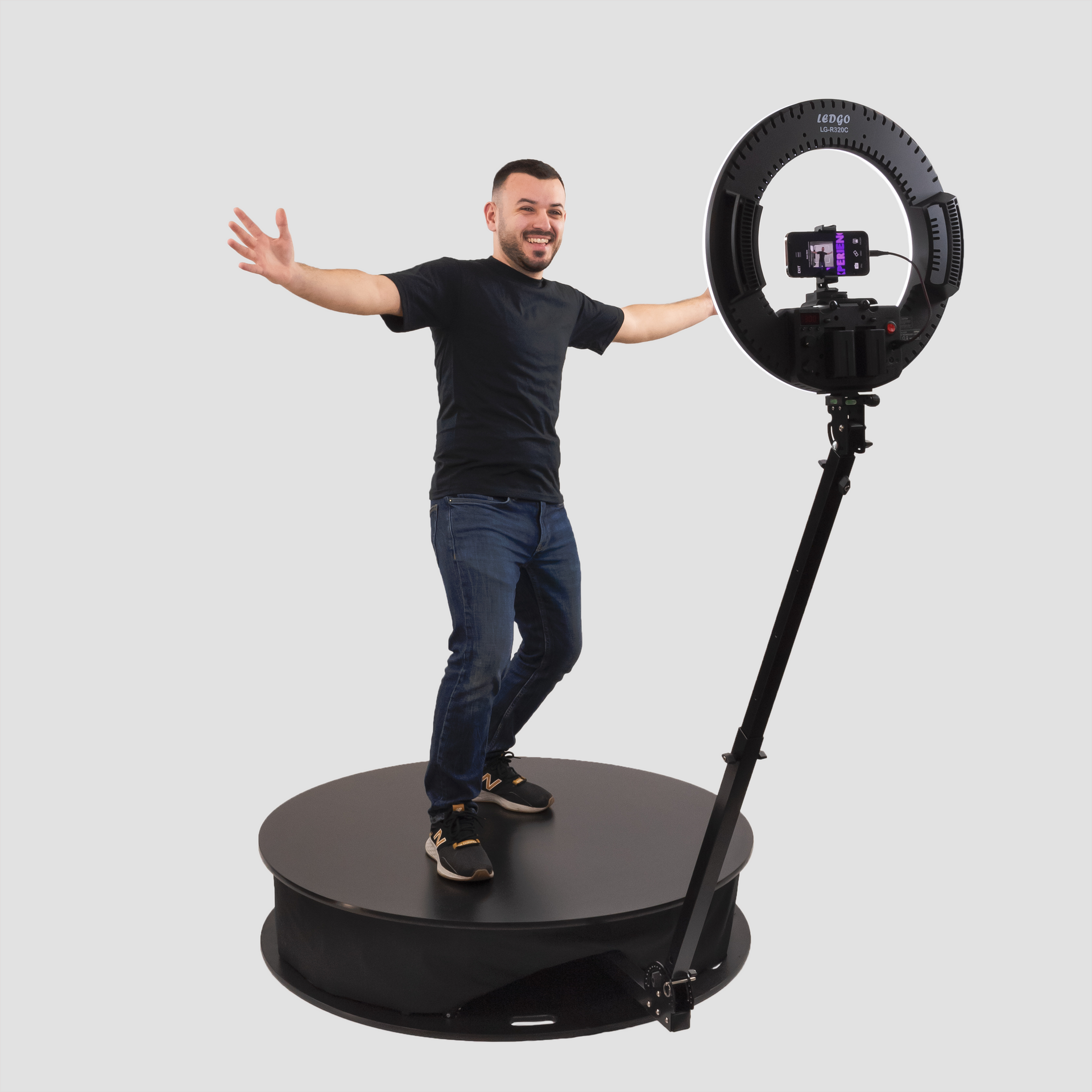 A man is standing on a turntable with his arms outstretched.