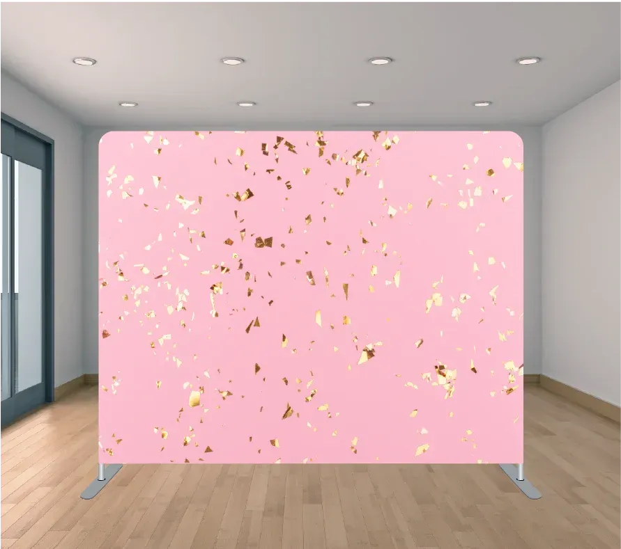 A pink backdrop with gold confetti on it is in a room.