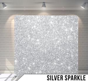 A silver sparkle backdrop is sitting in front of a white brick wall.