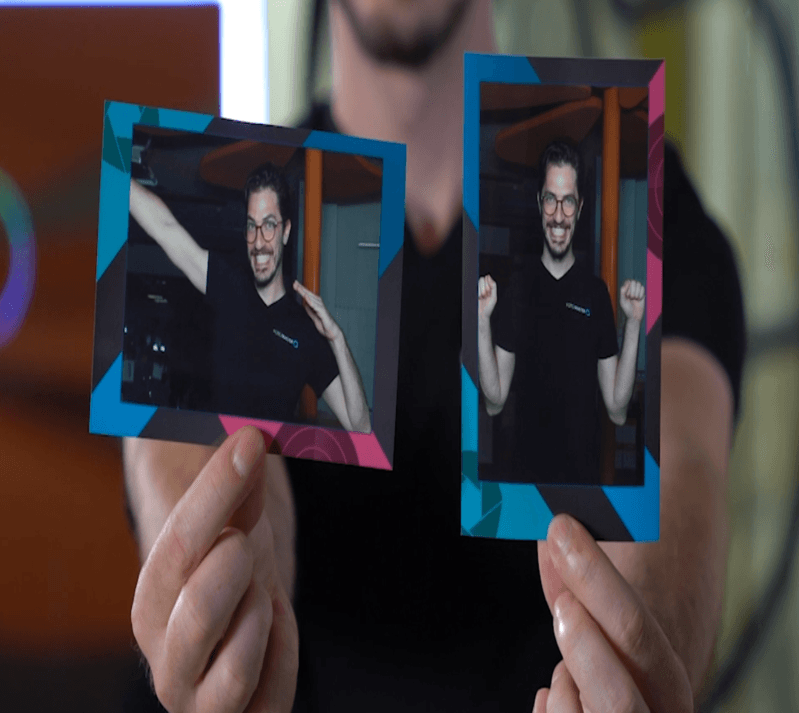 A man is holding two pictures of a man in a black shirt