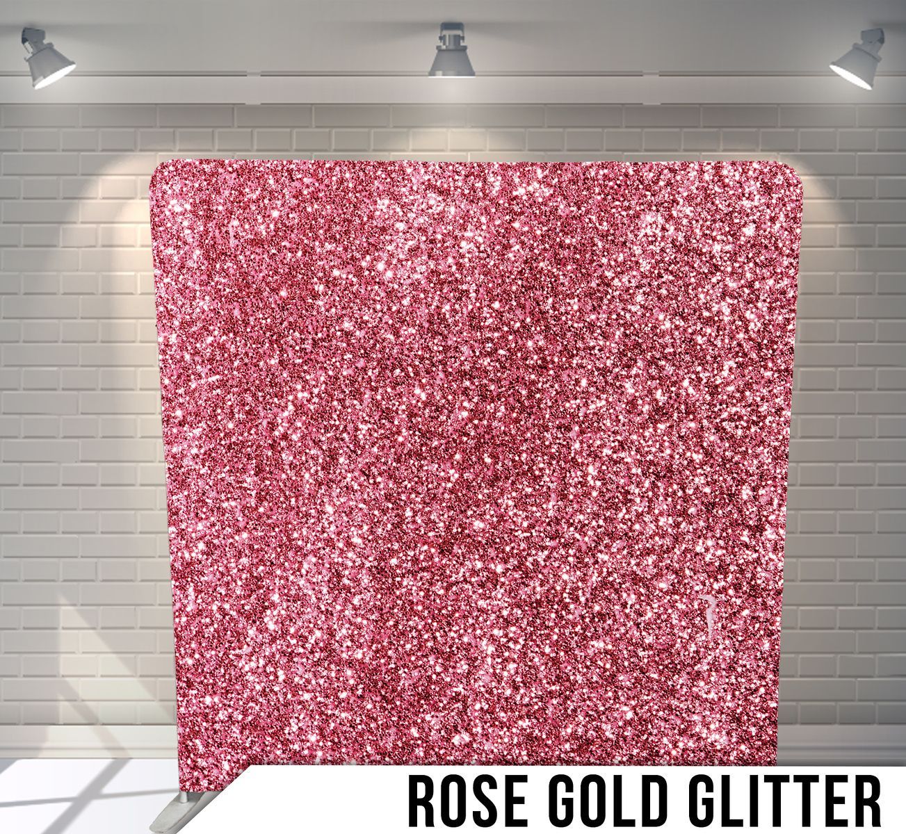 A pink glitter backdrop is sitting in front of a brick wall.