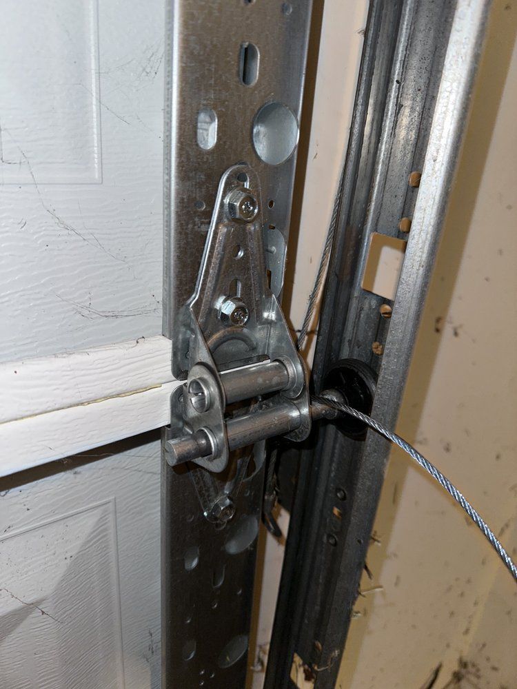 A close up of a garage door with a cable attached to it.