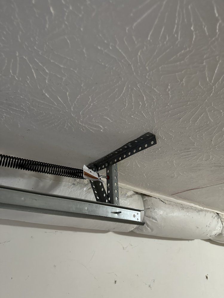 A close up of a garage door opener hanging from the ceiling.